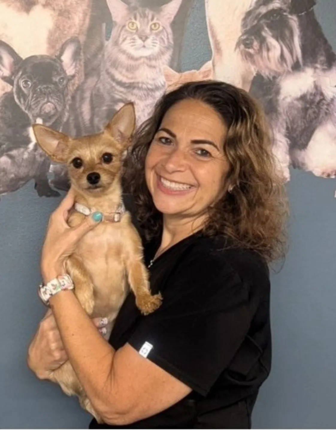 Portrait of Dr. Tami Lass holding a small brown dog Portrait of Dr. Tami Lass holding a small brown dog