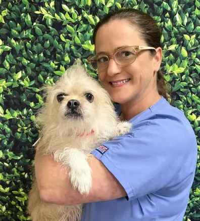 Candi's staff photo from Spanish Trail Animal Hospital where she is holding a puppy chihuahua.