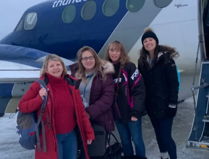 A photo of Allandale's staff posing in front of a plane in Peawanuk A photo of Allandale's staff posing in front of a plane in Peawanuk