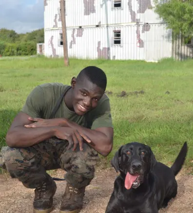 Devon, trainer at Pompano Pet Lodge, next to a dog