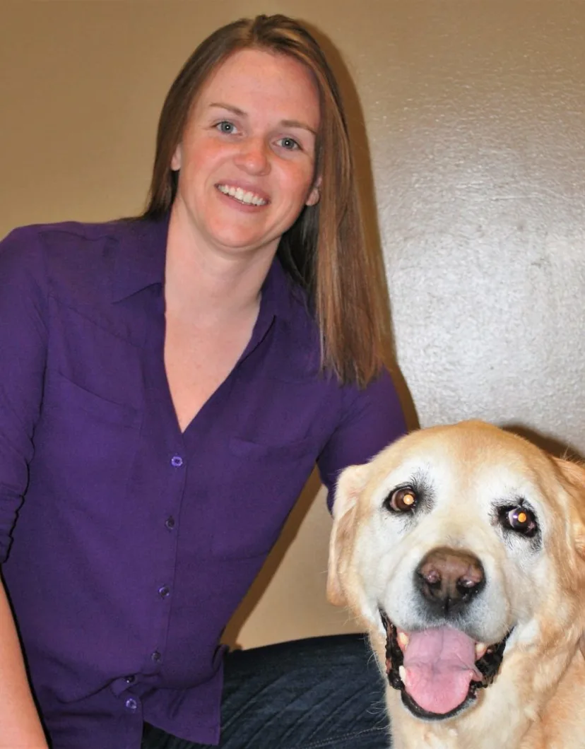 Corey Houk smiling at the camera while holding a dog