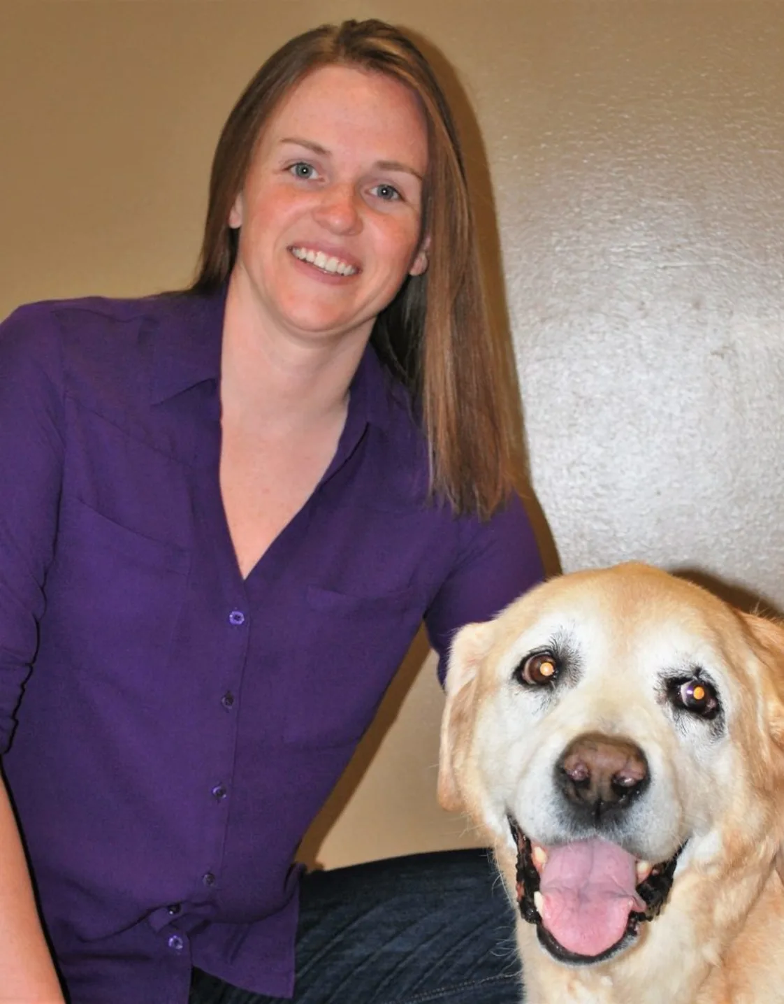 Corey Houk smiling at the camera while holding a dog Corey Houk smiling at the camera while holding a dog