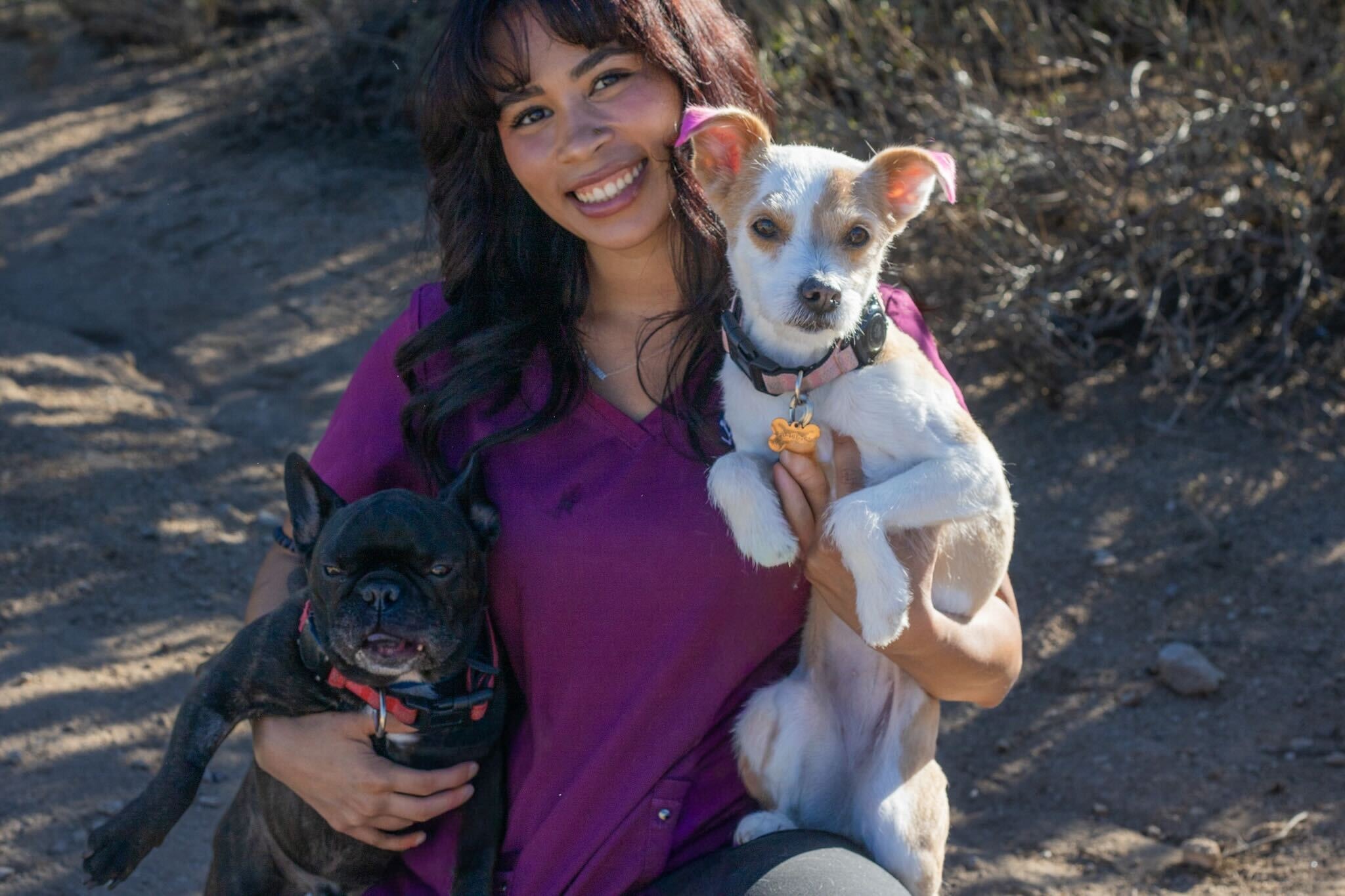 Ayianna Hernandez-Ware holding a white dog with a green collar
