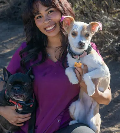 Ayianna Hernandez-Ware holding a white dog with a green collar Ayianna Hernandez-Ware holding a white dog with a green collar