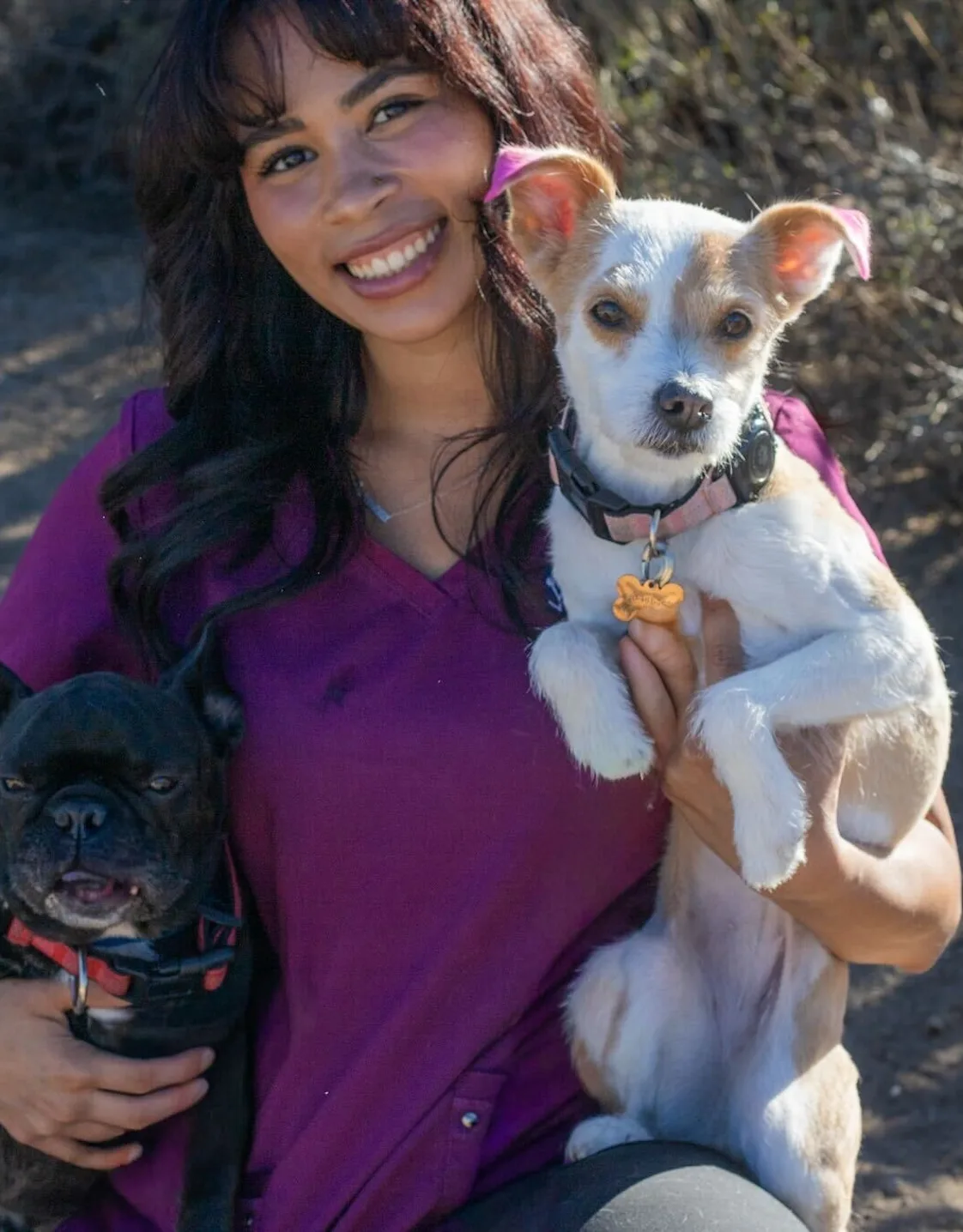 Ayianna Hernandez-Ware holding a white dog with a green collar Ayianna Hernandez-Ware holding a white dog with a green collar