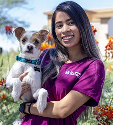 Ayianna Hernandez-Ware holding a white dog with a green collar Ayianna Hernandez-Ware holding a white dog with a green collar