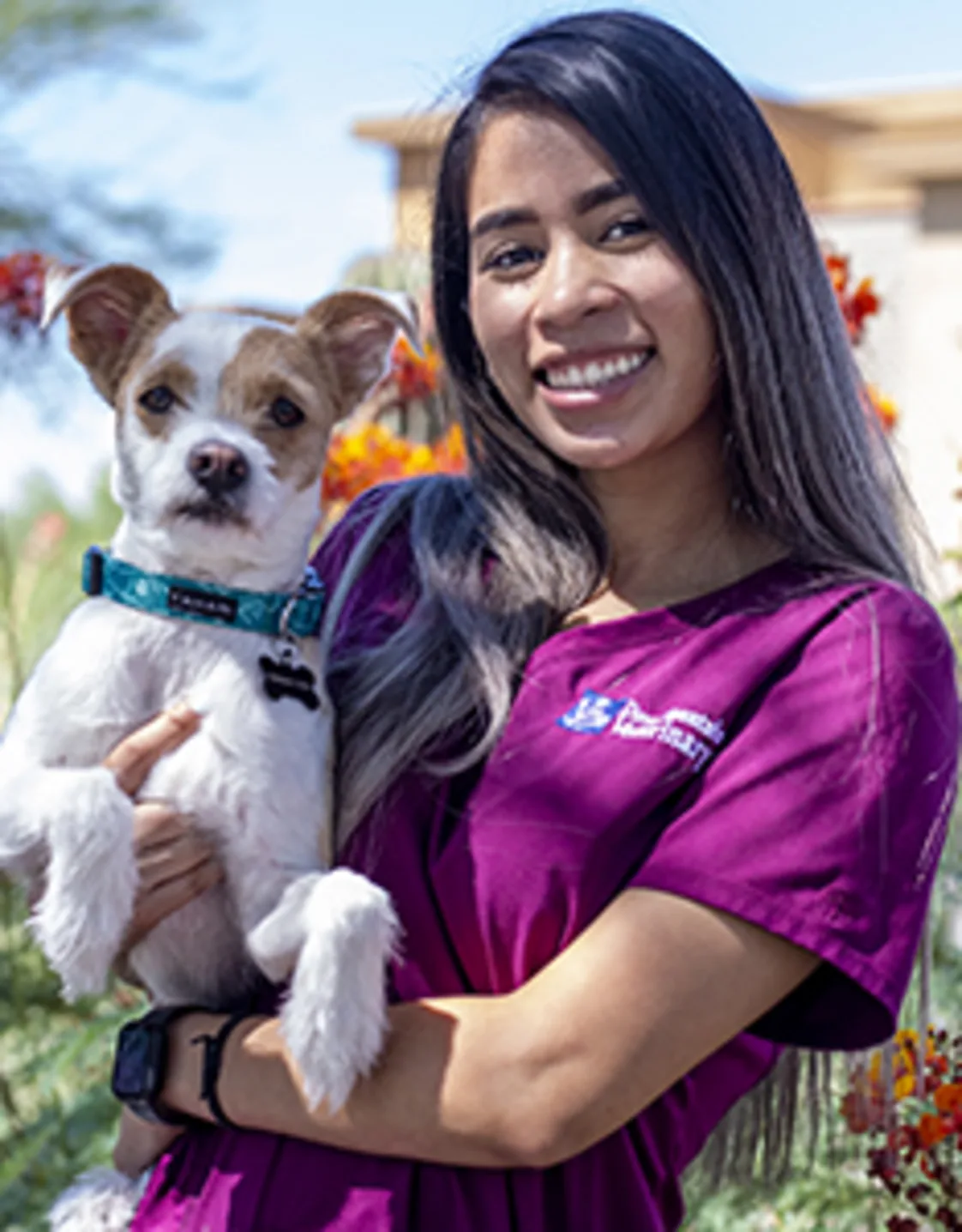 Ayianna Hernandez-Ware holding a white dog with a green collar Ayianna Hernandez-Ware holding a white dog with a green collar
