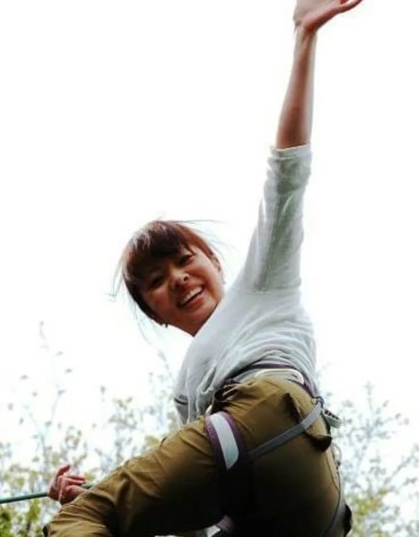 Natsuko climbing a rock and waving to the camera