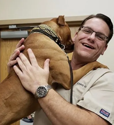 Chris Oldt hugging a brown dog