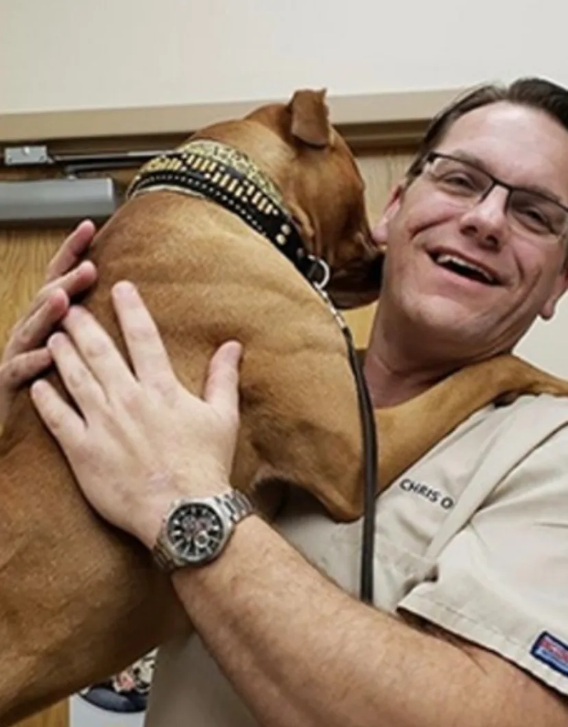 Chris Oldt hugging a brown dog
