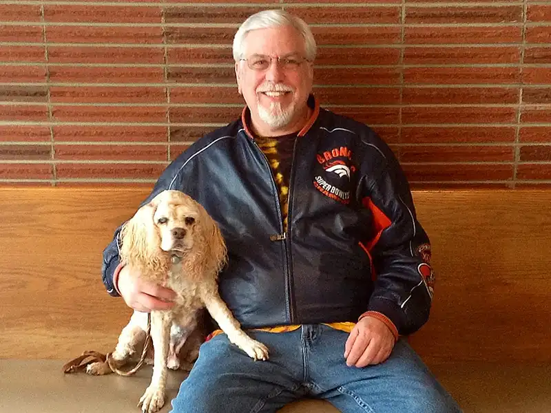 Client sitting and holding their dog