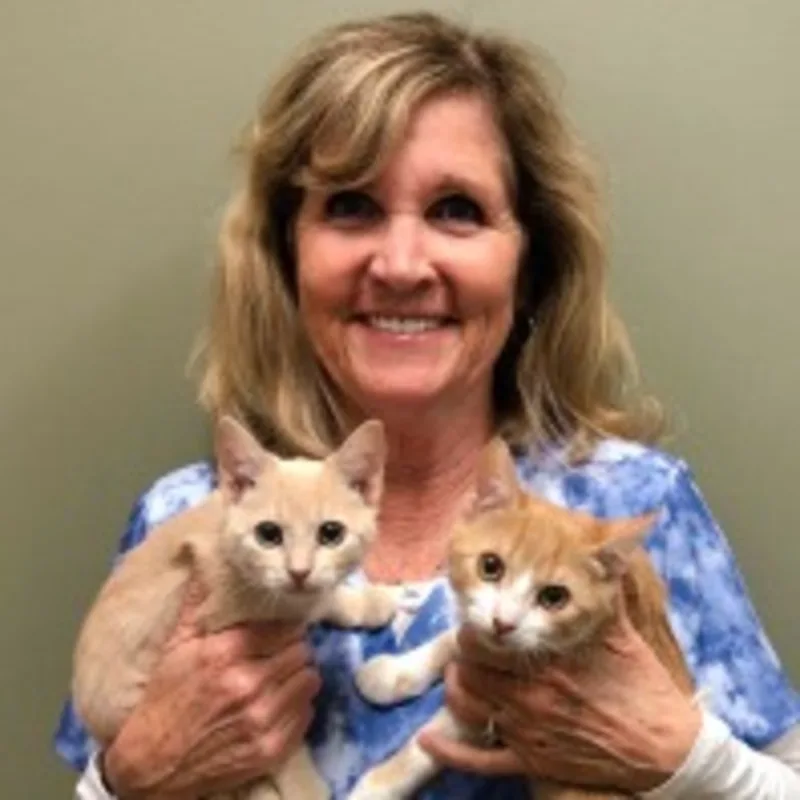 Marilyn inside holding two small tan cats Marilyn inside holding two small tan cats