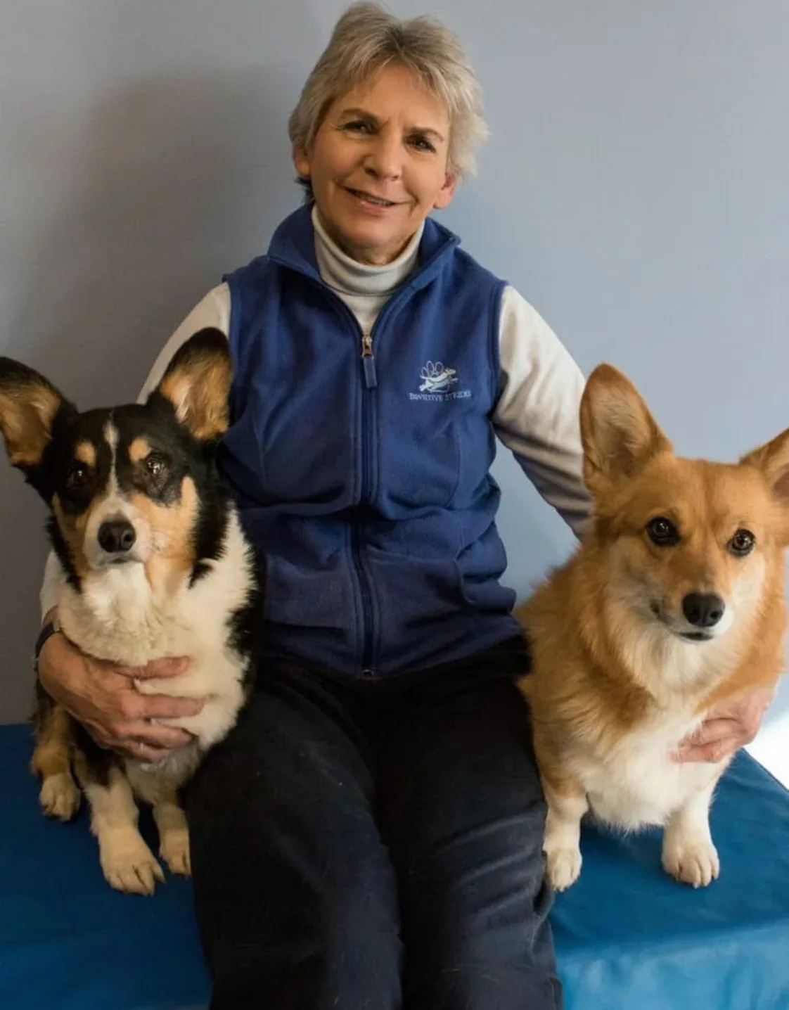 Dr. Harder smiling with two corgis. Dr. Harder smiling with two corgis.