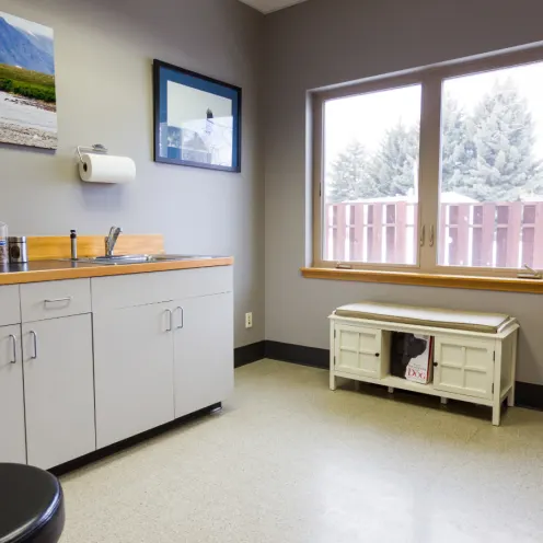 Gray exam room with a sitting bench 
