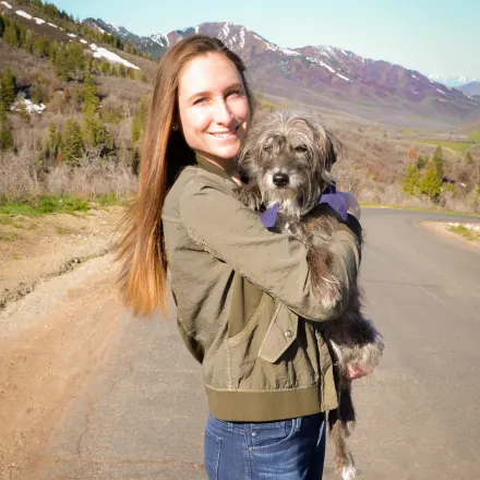 Dr. Sophie Charlton staff photo from East Valley Veterinary Clinic where she is smiling and holding her dog on a hike.
