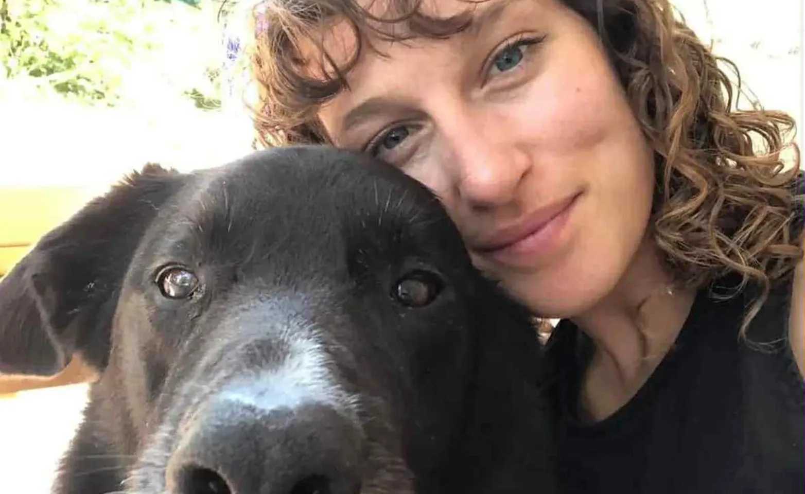 Hilary Strongs smiling next to a black and white dog. Hilary Strongs smiling next to a black and white dog.