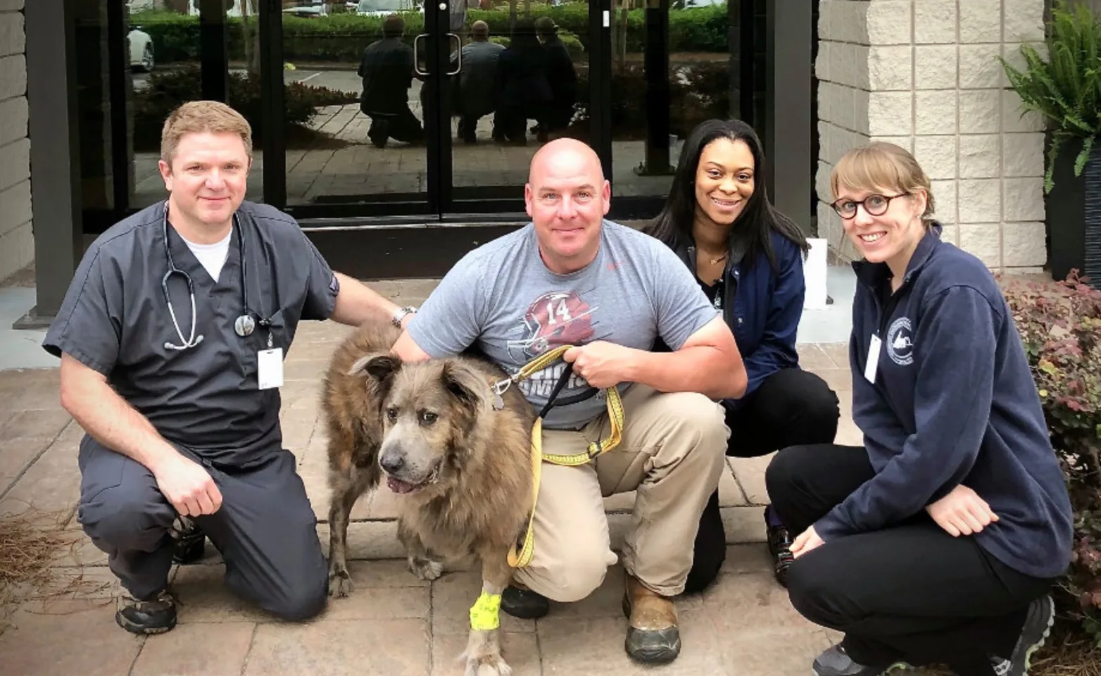 Staff Members Outside with a Brown Dog