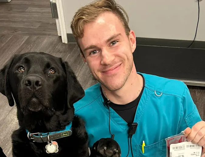 A photo of a veterinary student with a black lab A photo of a veterinary student with a black lab