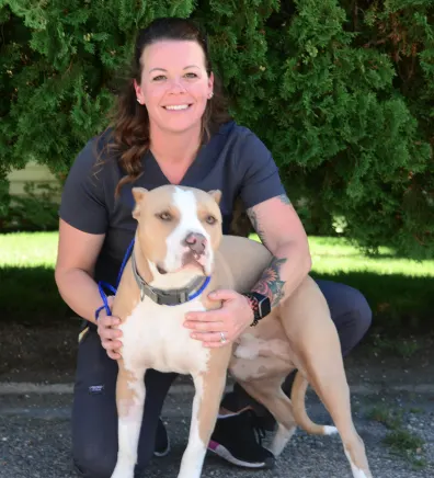 Meagan holding a dog in front of the Eastside sign