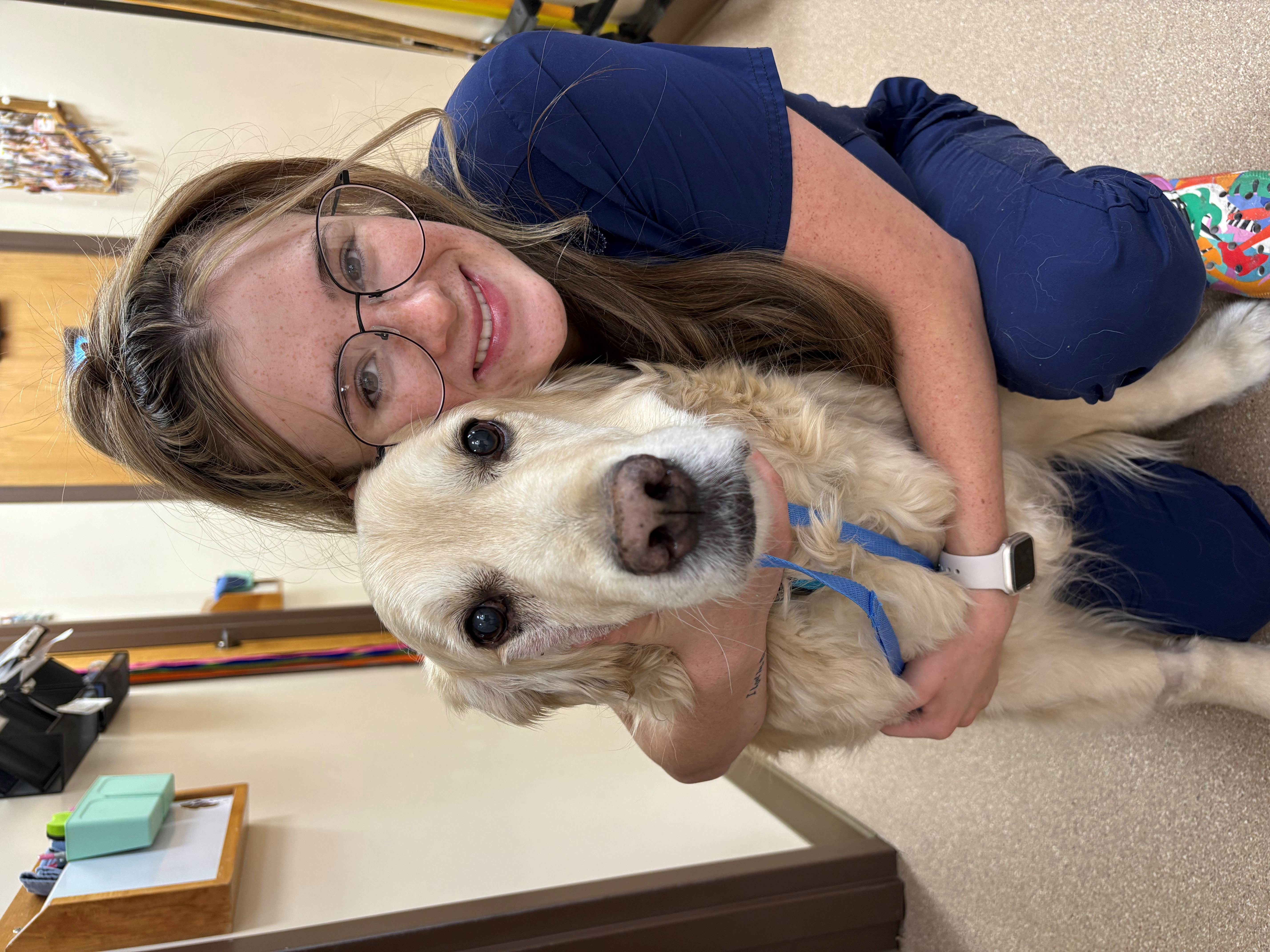 Staff member hugging dog