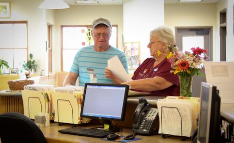 Client and staff discussing paperwork in front of reception desk