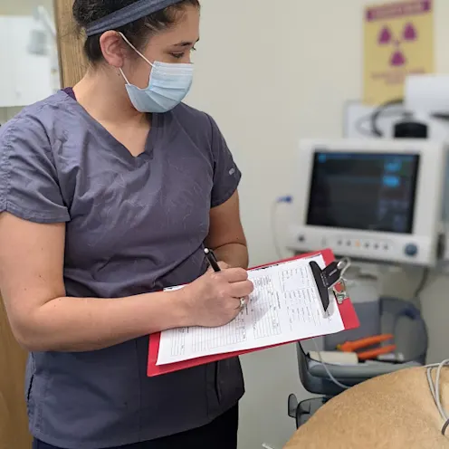 Staff member writing on a notepad Staff member writing on a notepad