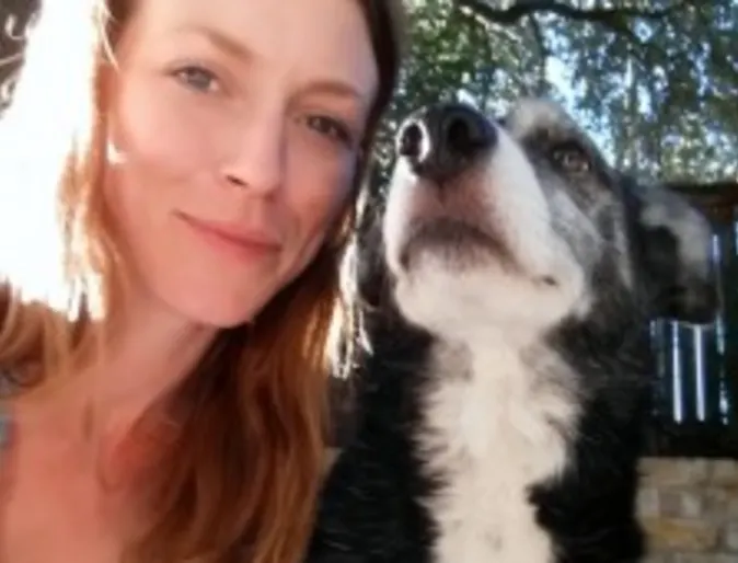 A woman poses with a dog