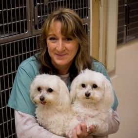 Mary holding 2 small white dogs