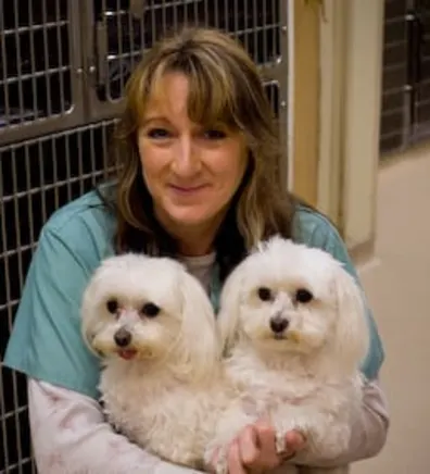 Mary holding 2 small white dogs