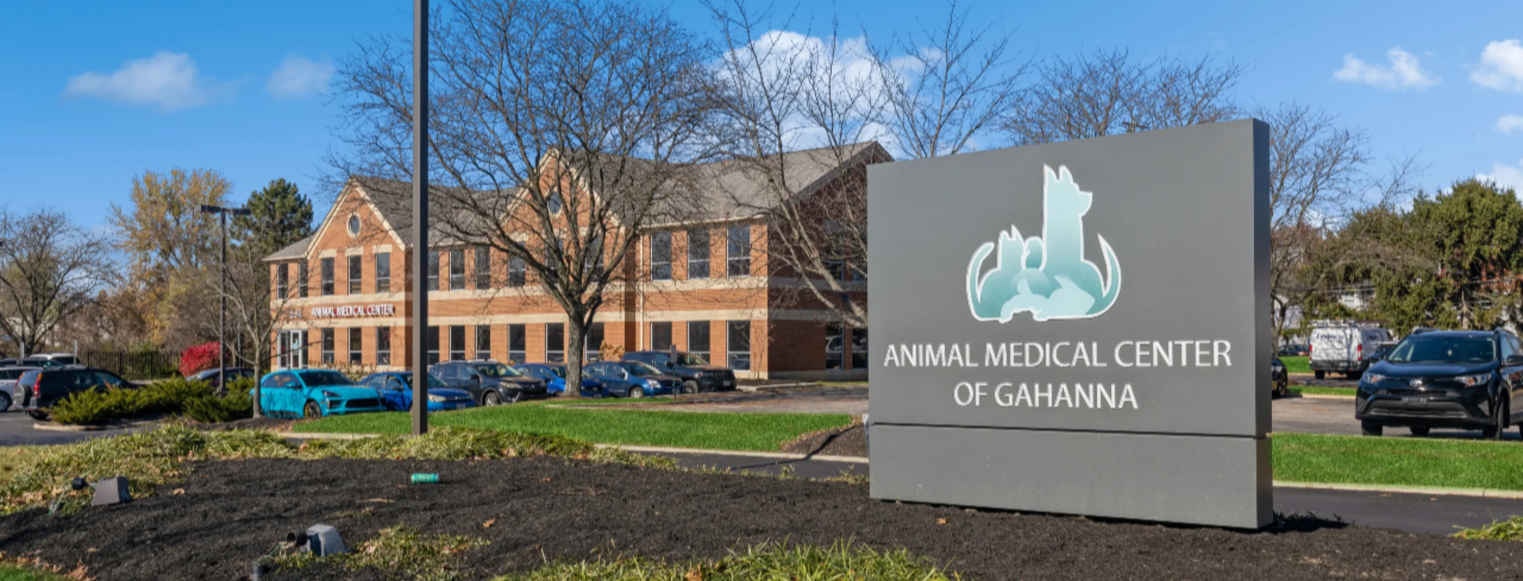 Exterior photo of a brown building with a sign reading Animal Medical Center of Gahanna in the foreground