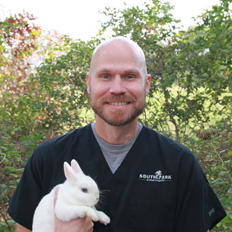 Dr. Singleton smiling with small dog Dr. Singleton smiling with small dog