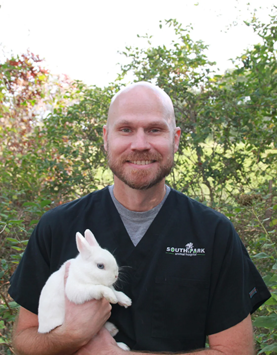 Dr. Singleton smiling with small dog Dr. Singleton smiling with small dog