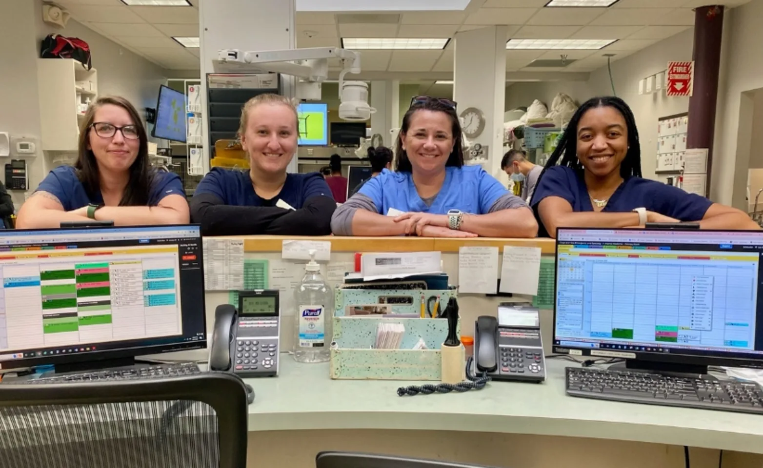  Four staff members smiling by the reception desk.