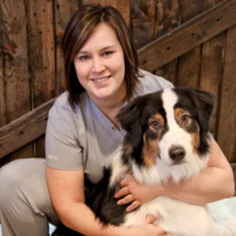 A veterinarian posing with a dog A veterinarian posing with a dog