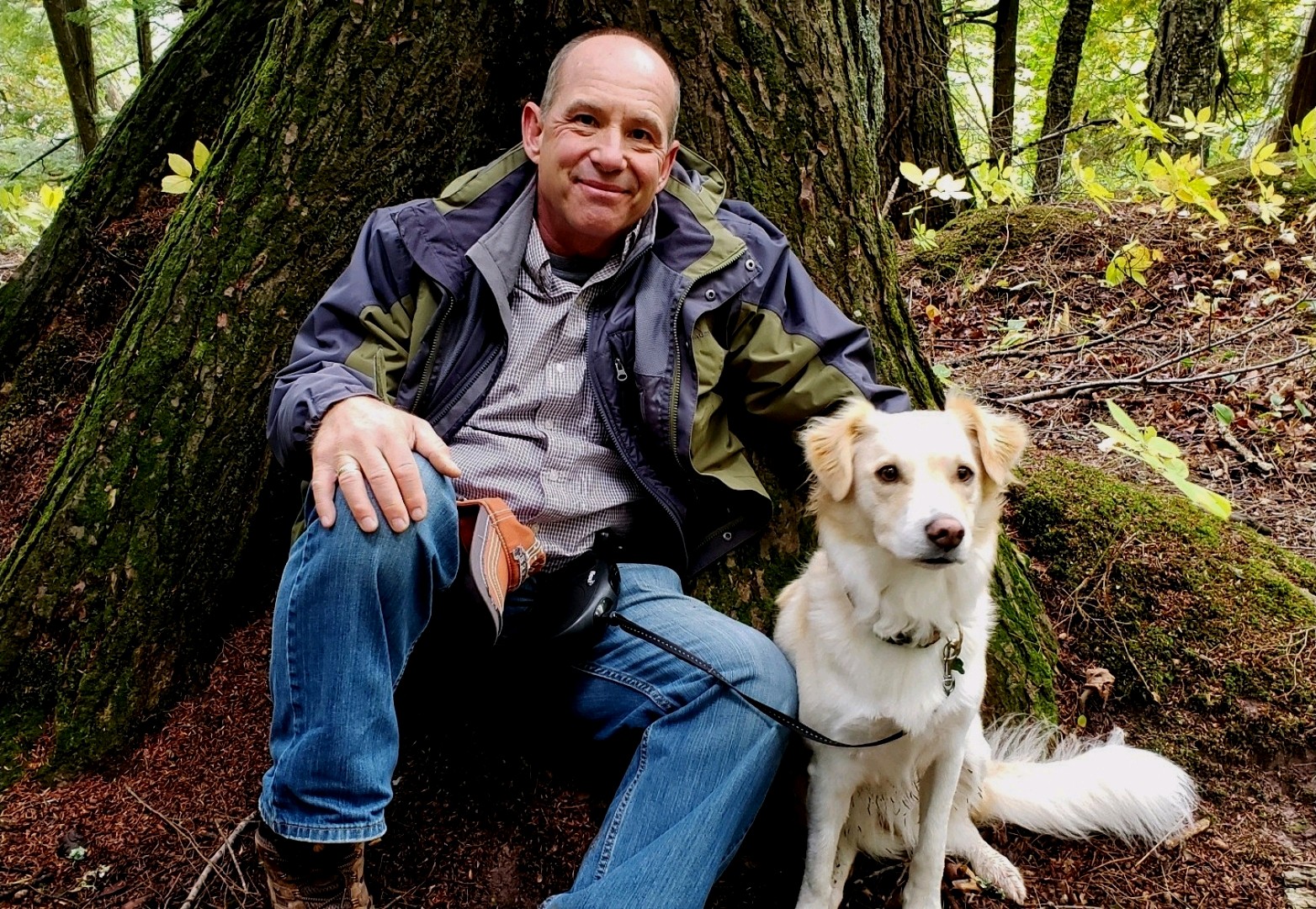 Dr. Dale Covy with white dog in front of a tree