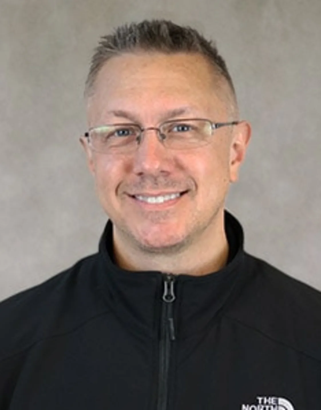 Dr. Jason Matthew smiling in front of a grey backdrop Dr. Jason Matthew smiling in front of a grey backdrop