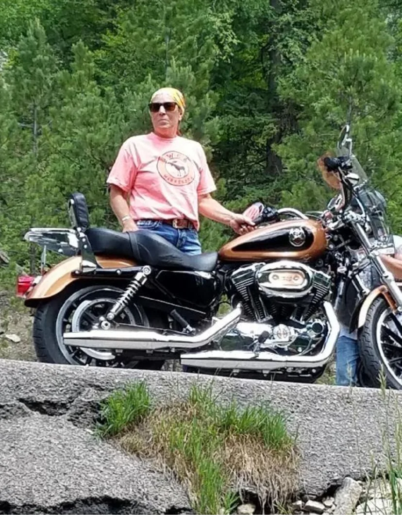 Connie's staff photo from Stillwater Veterinary Clinic posing on her Harley outside 