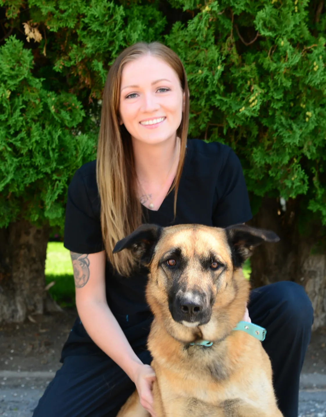 Cheyenne holding a dog and sitting in front of the Eastside sign Cheyenne holding a dog and sitting in front of the Eastside sign