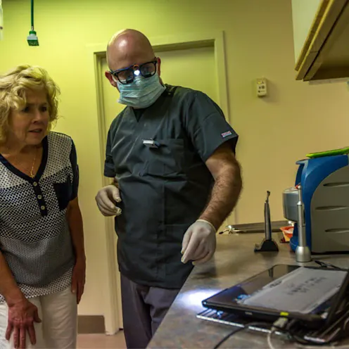 Veterinarian showing a pet parent an image Veterinarian showing a pet parent an image