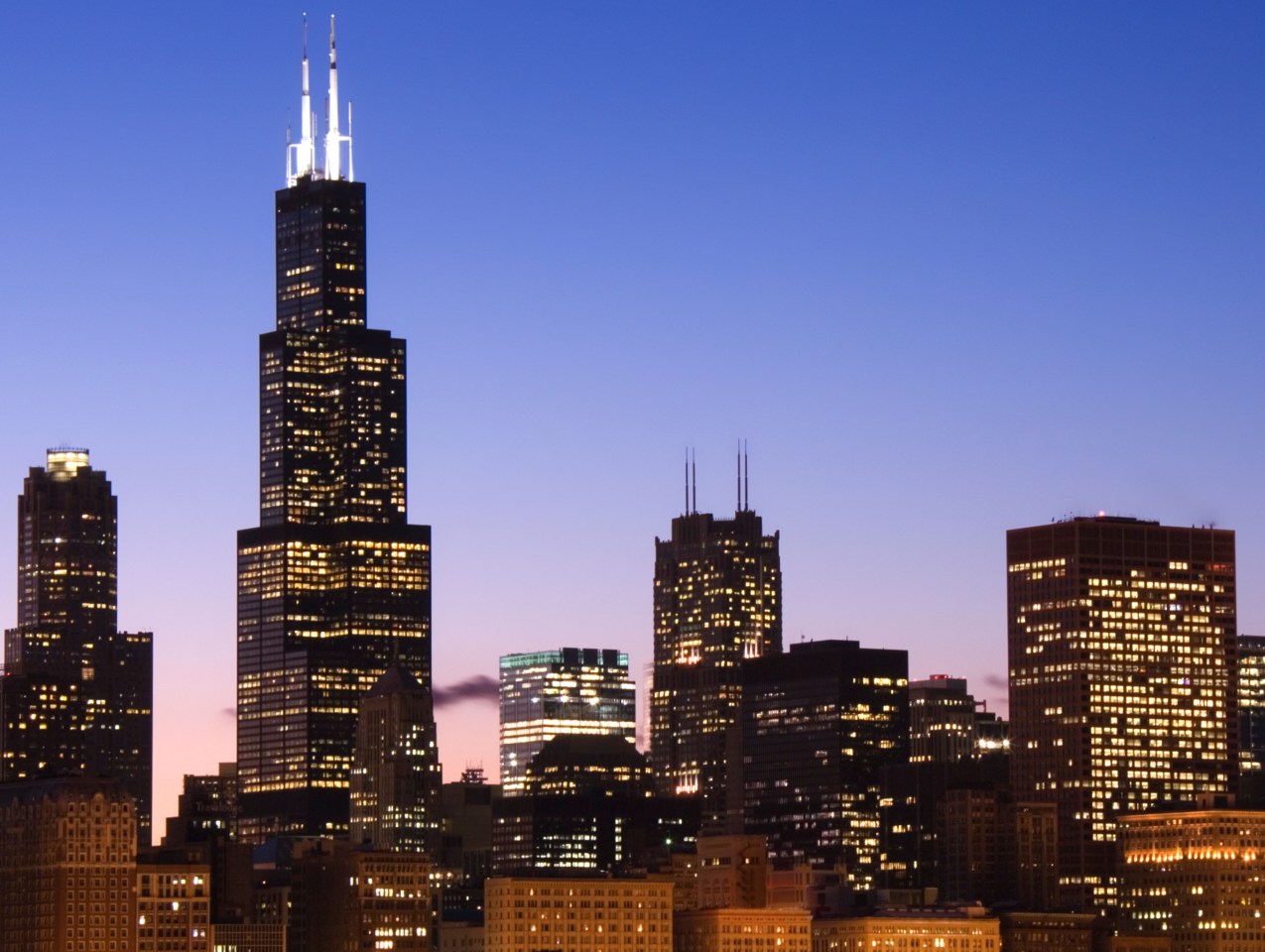Silhouetted cityscape against a sunset. 