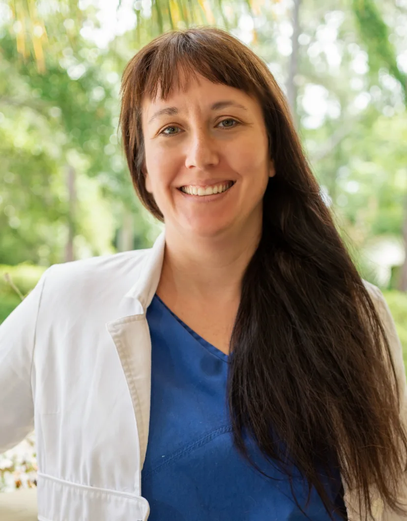 Dr. Heather Trelease's staff photo from Plantation Animal Hospital who is smiling outside who's about to get her picture taken.