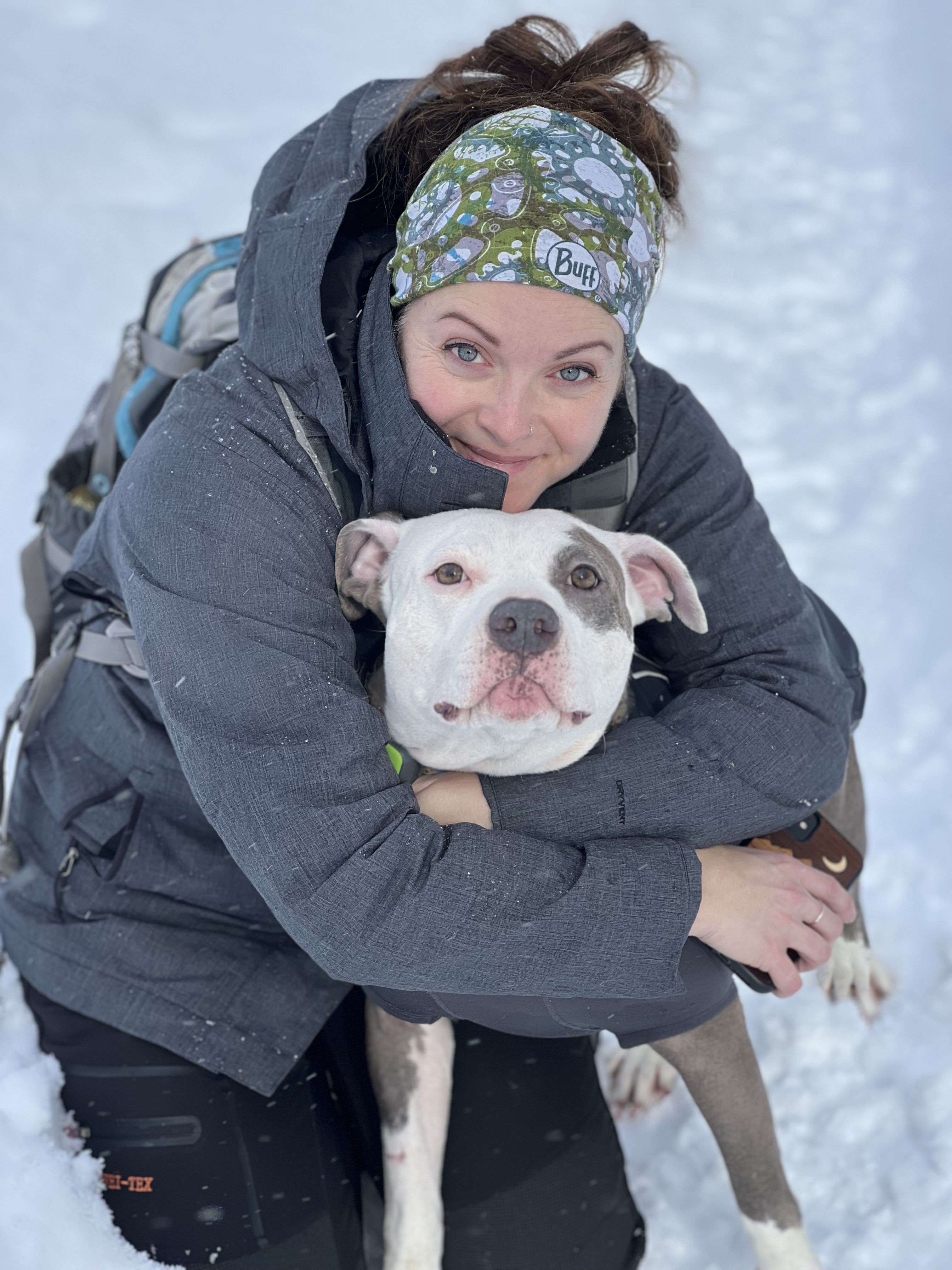 Katie Silva smiling with a white and grey dog
