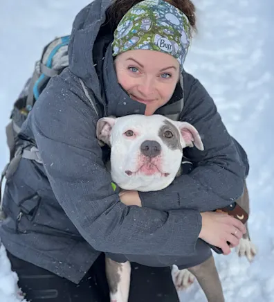 Katie Silva smiling with a white and grey dog Katie Silva smiling with a white and grey dog