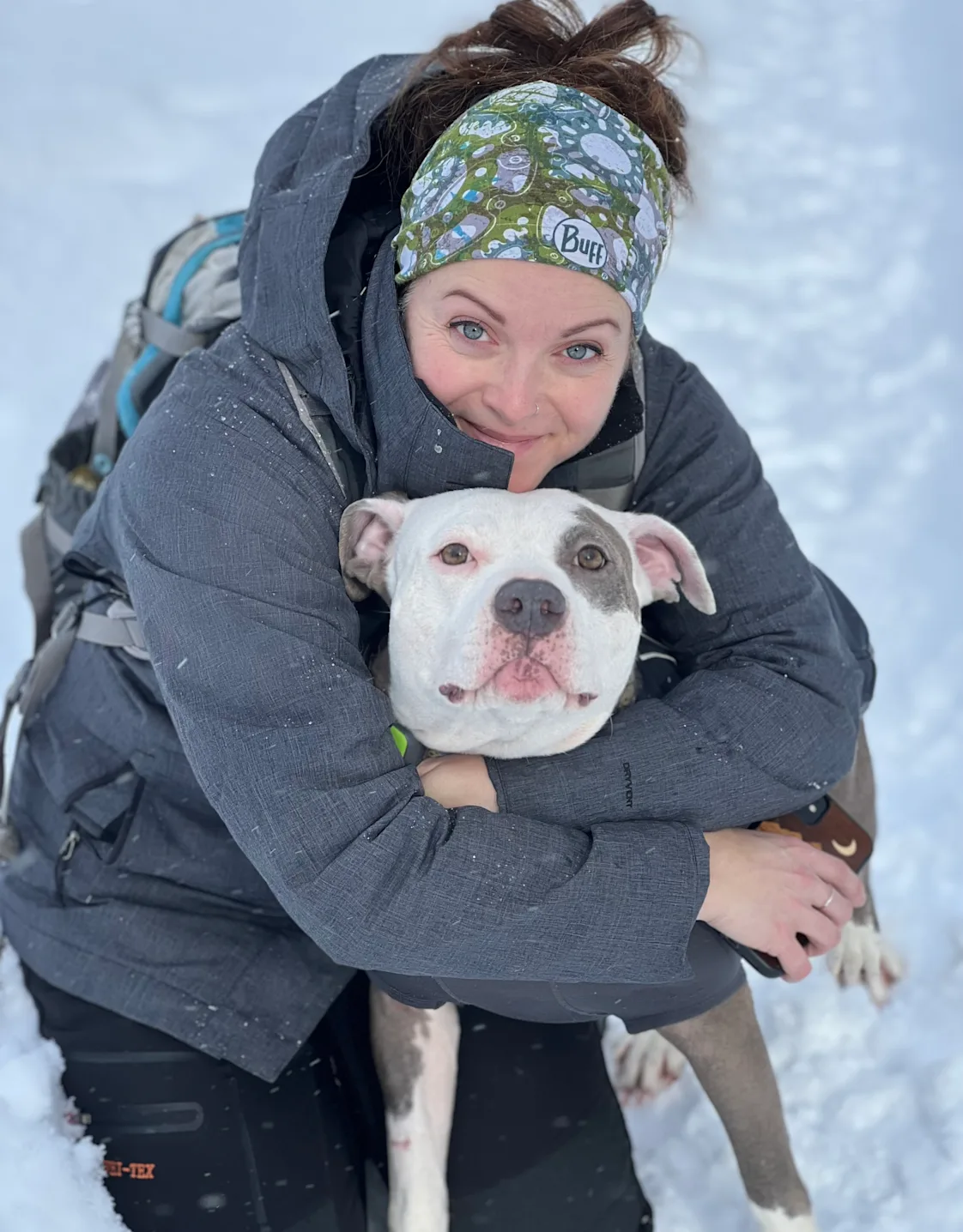 Katie Silva smiling with a white and grey dog Katie Silva smiling with a white and grey dog
