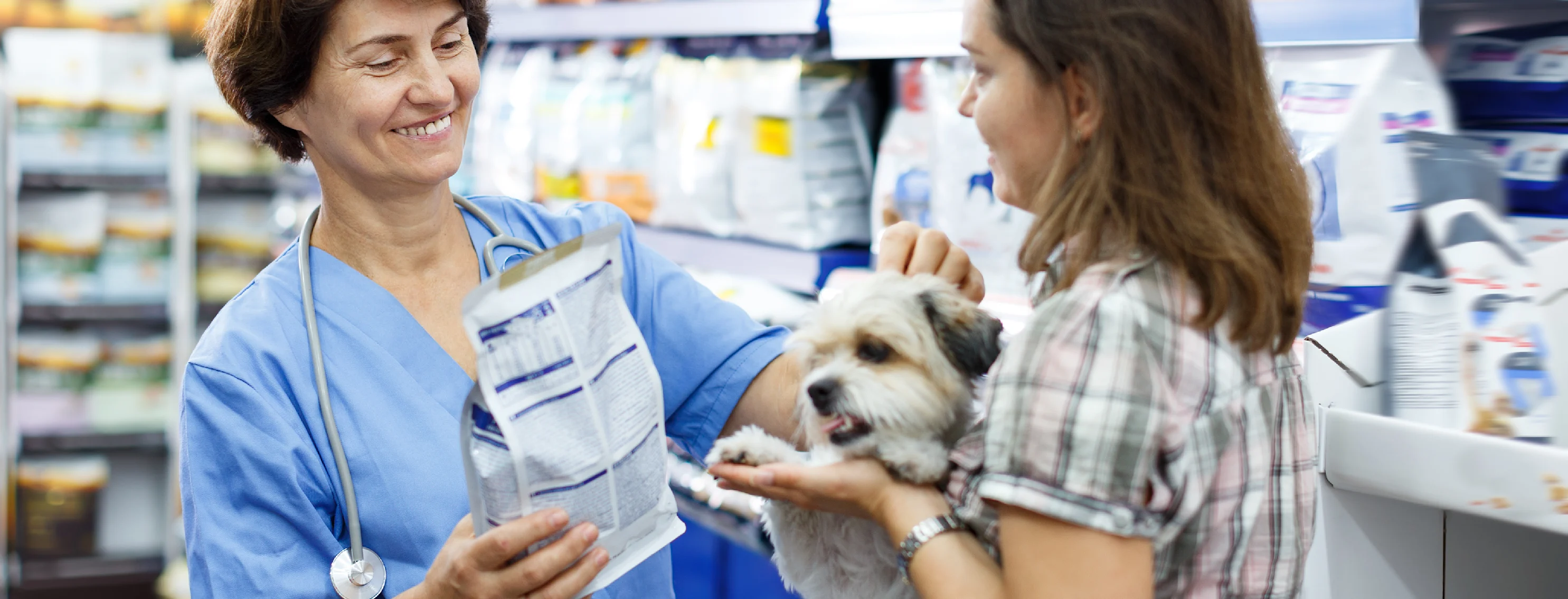 Woman giving prescription food to customer and dog Woman giving prescription food to customer and dog