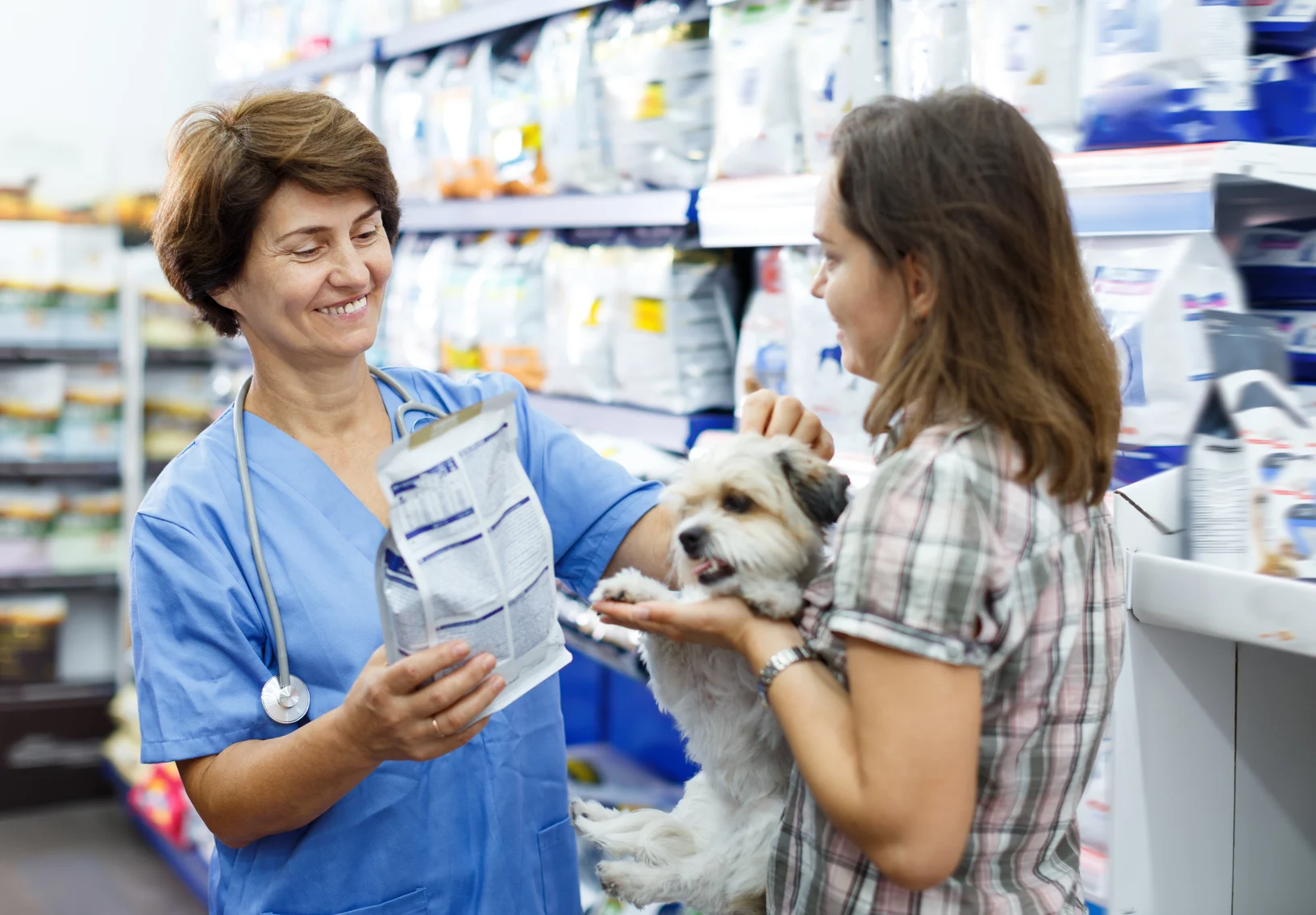 Woman giving prescription food to customer and dog 