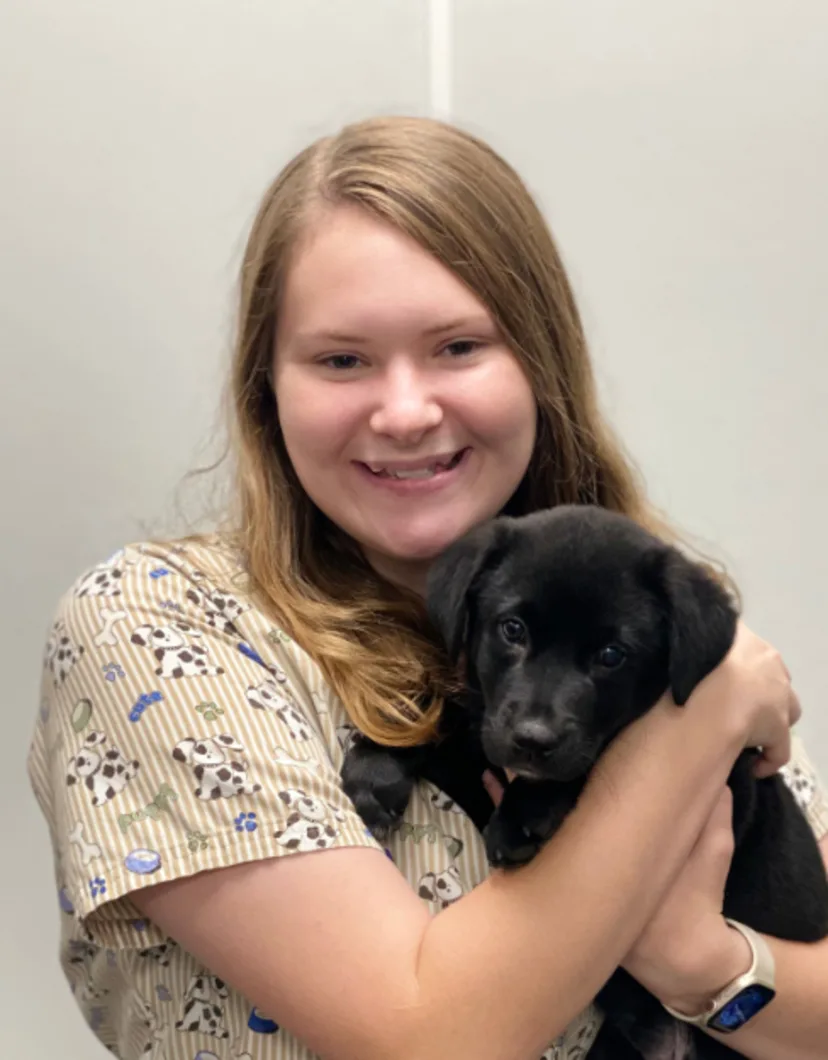 Layla Davis holding a small puppy with short black fur