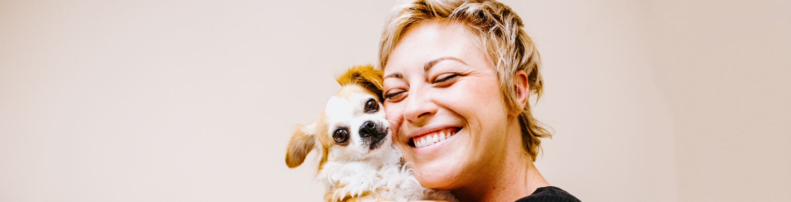 Woman smiling and hugging dog at Overland Veterinary Clinic
