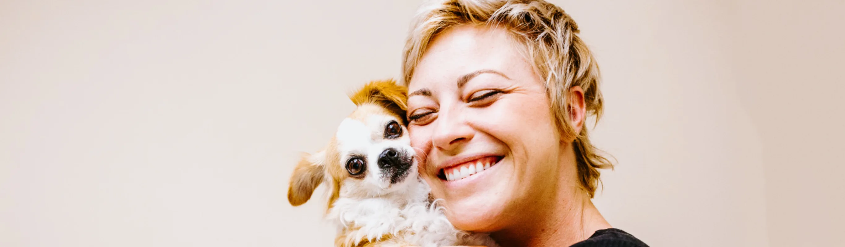 Woman smiling and hugging dog at Overland Veterinary Clinic