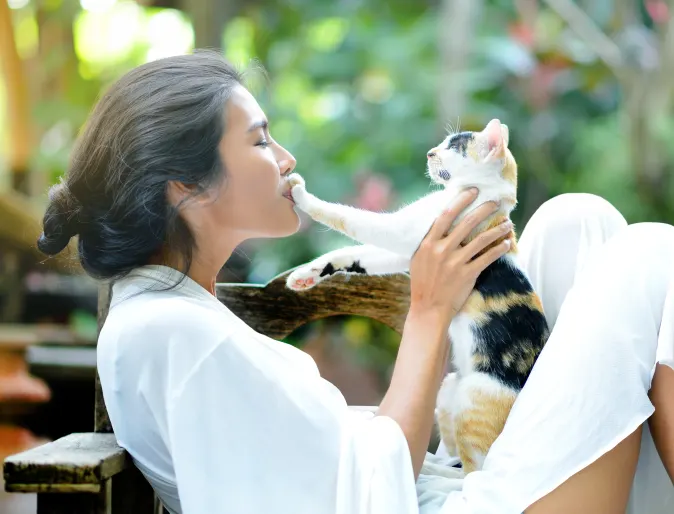 Woman with cat outside sitting down